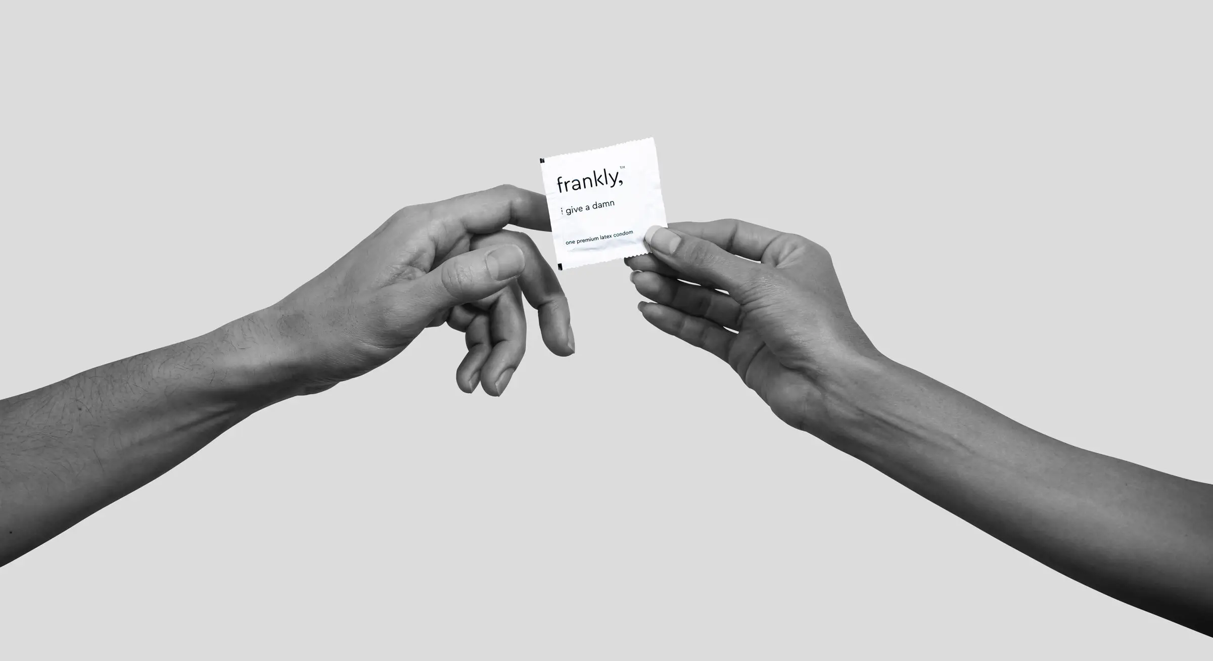 Two hands passing condom